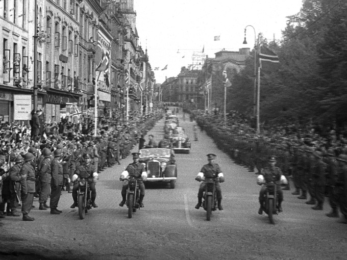 Leidd av politi på motorsyklar går bilkortesjen med Kronprins Olav opp Karl Johans gate mot Slottet. Foto: NTB arkiv / Scanpix